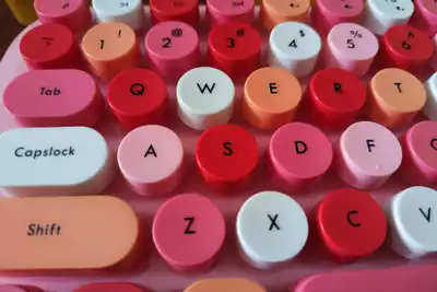 Close-up of a keyboard with round keycaps in pink, red and white